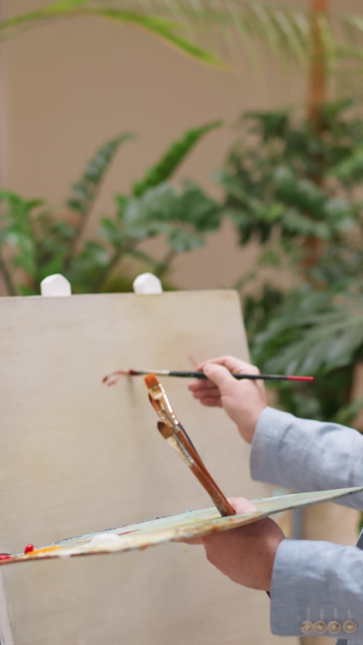 예술가는 빈 캔버스에 컬러 스트로크를 만니다. 캐주얼 재을 입은 영감을 받은 남자는 스튜디오에서 넓은 질로 그림을 그립니다. 재능있는 화가 예술 작품을 만니다