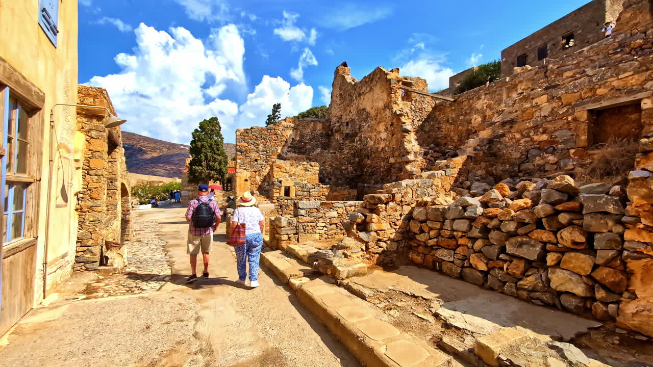 Tourists visit the medieval Spinalonga Island Fortress castle ruins which was also a former leper colony on Crete, Greece