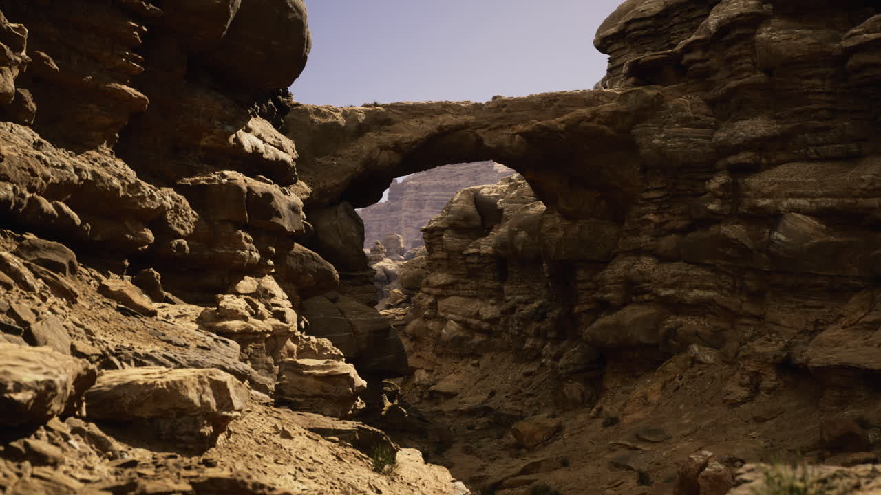 Rock formations create a natural arch in a desert canyon after sunset