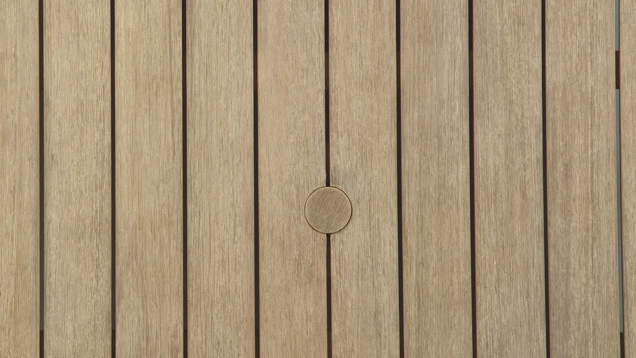 Camera descends toward the slatted tabletop, highlighting the centered umbrella opening