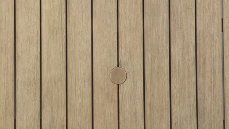 camera descends toward the slatted tabletop, highlighting the centered umbrella opening