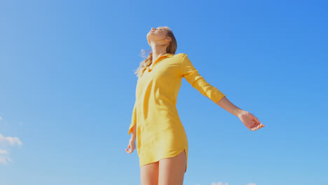 low angle view of young caucasian woman standing with arms crossed on the beach 4k