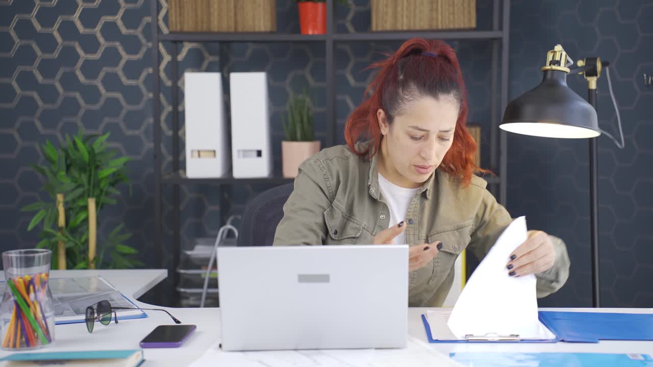 mujer de negocios buscando documentos en la mesa.