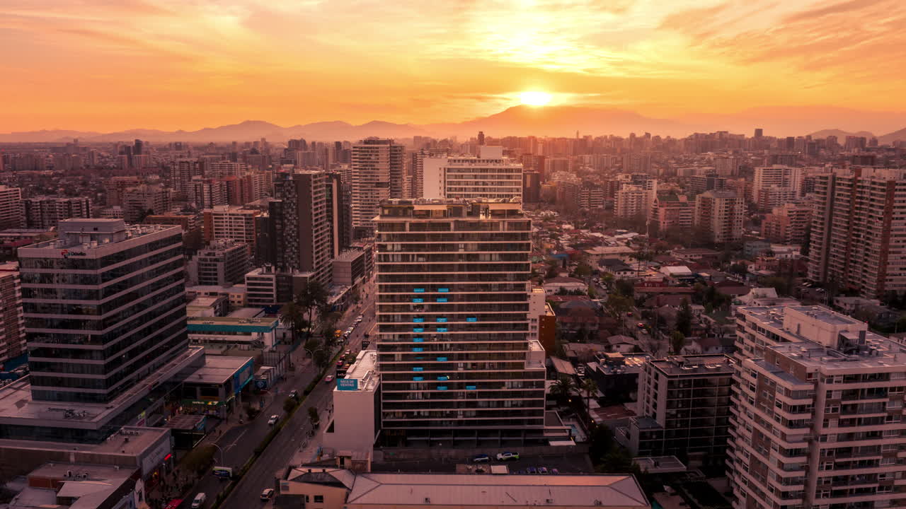 Hyperlapse aéreo semi orbital cativante de Santiago durante o pôr do sol dourado, com horizonte urbano brilhante e montanhas distantes
