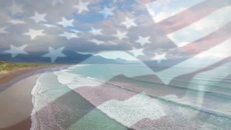 digital composition of waving us flag over hands showing thumbs up against aerial view of the beach