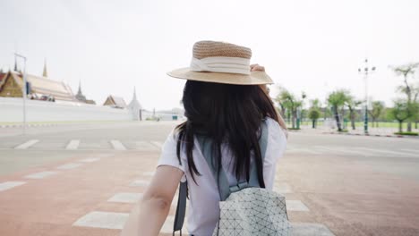 cheerful young asian woman holding his boyfriend's hand crossing the road in bangkok