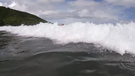 Girl-swimming-in-slow-motion-on-top-of-a-wave-on-a-beach-in-Costa-Rica