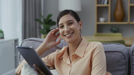 woman using a tablet on a couch