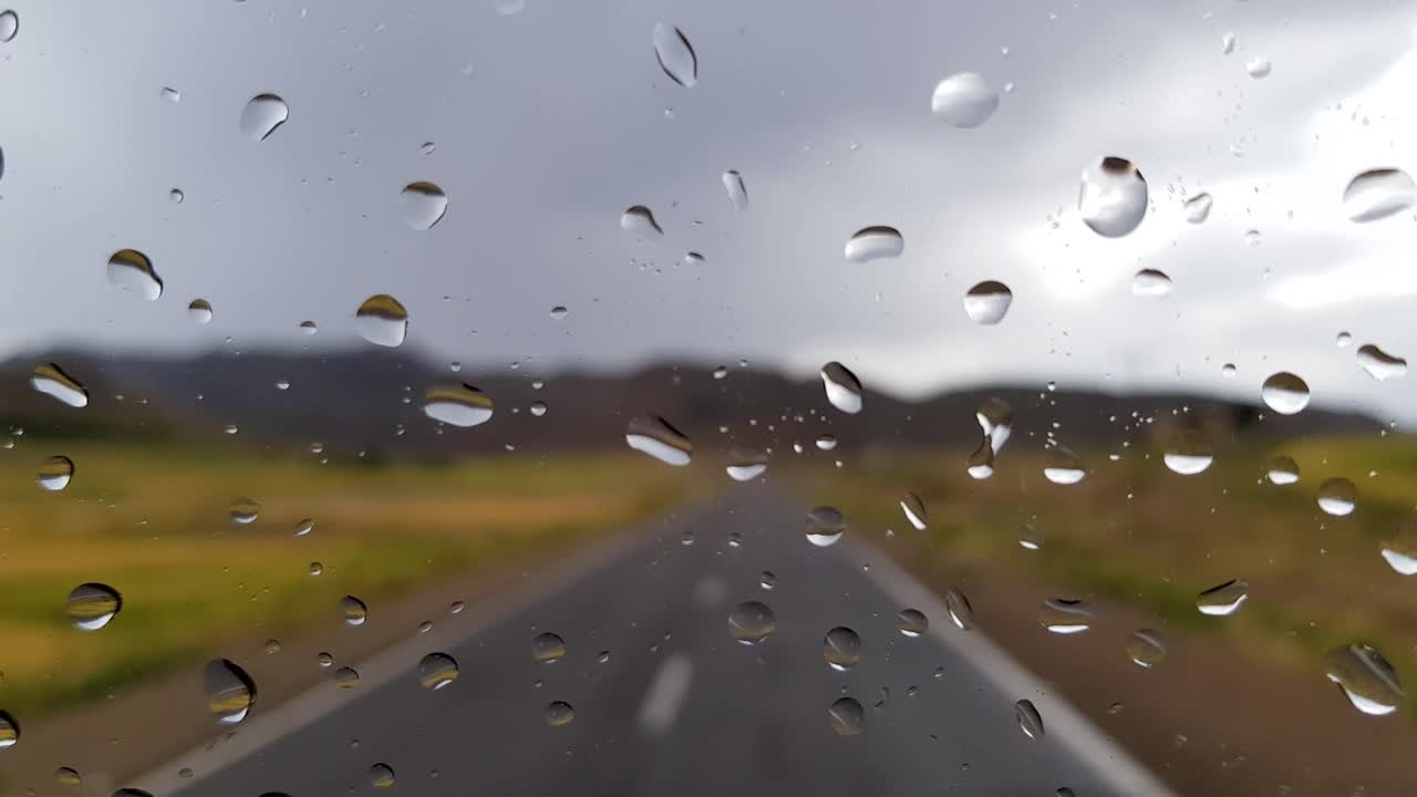 산악 자연 속에서 도로를 운전하고 시골 풍경과 흐린 하늘에서 이슬비가 내리고 풍경이 흐릿한 구불구불한 차선을 지나갑니다.