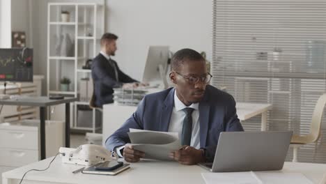 african american broker phone calling client in office