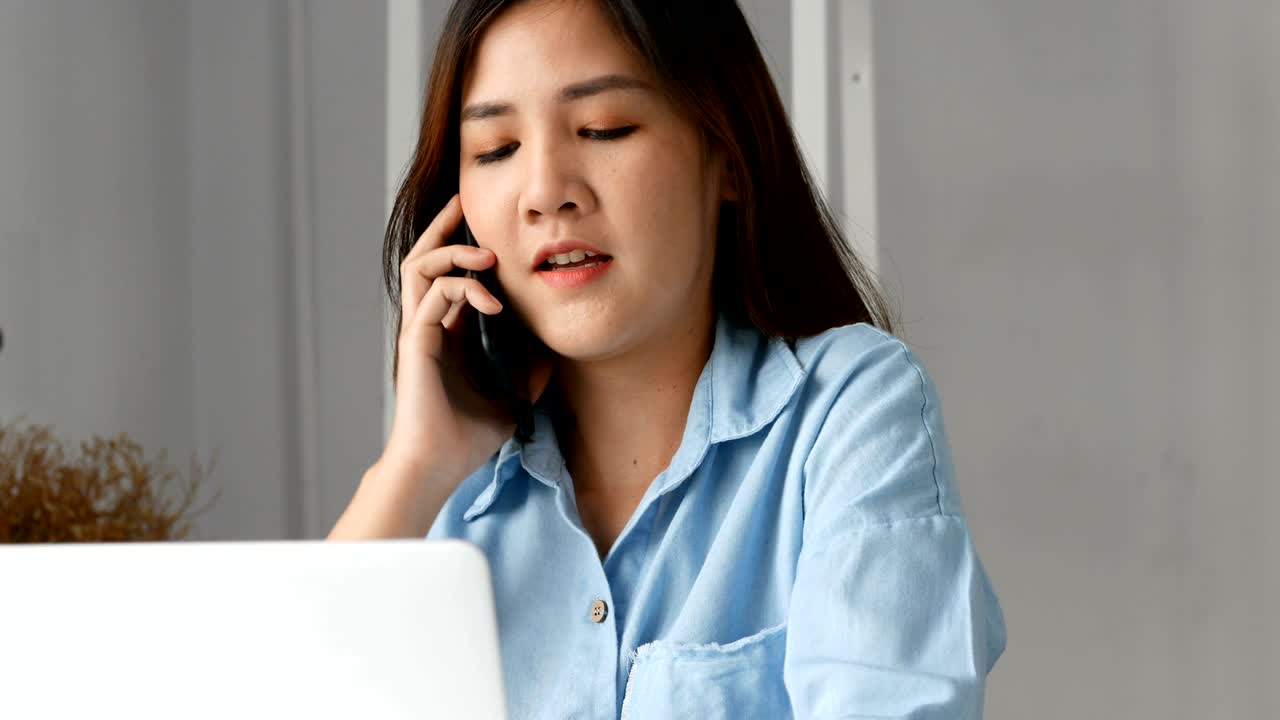 젊은 아시아 사업주들이 가정 사무실에서 컴퓨터 pc와 스마트 폰을 사용합니다.