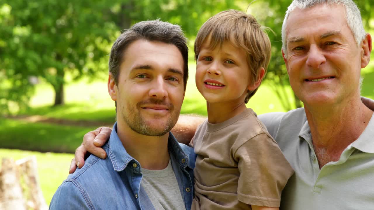 Tre generazioni di uomini che sorridono alla fotocamera