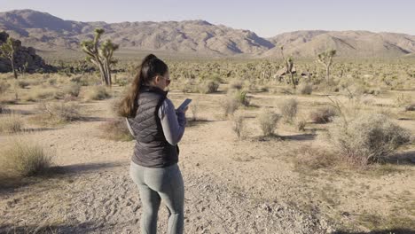 Niña-Fotografiando-El-Parque-Nacional-Joshua-Tree-Desierto-De-California-Con-Una-Cámara-Sony-A1---En-Su-Teléfono-A-Lo-Ancho-Del-Paisaje