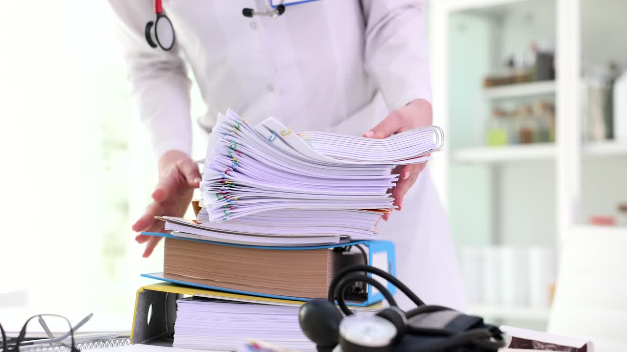 Medical Professional Handling Large Stack of Patient Files and Paperwork