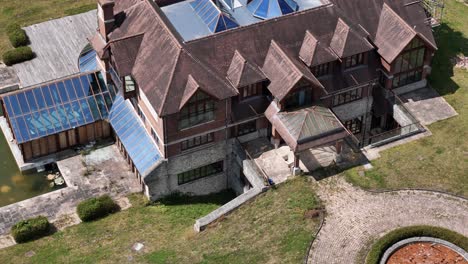 unfinished celebrity mansion aerial view circling glass rooftop real estate and landscaped gardens
