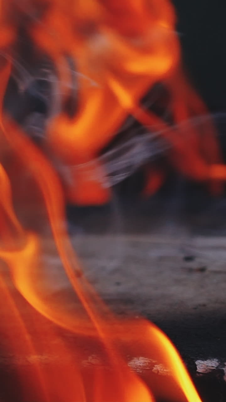 Flaming and burning dangerous fire. Burning firewood. Slow motion Vertical video