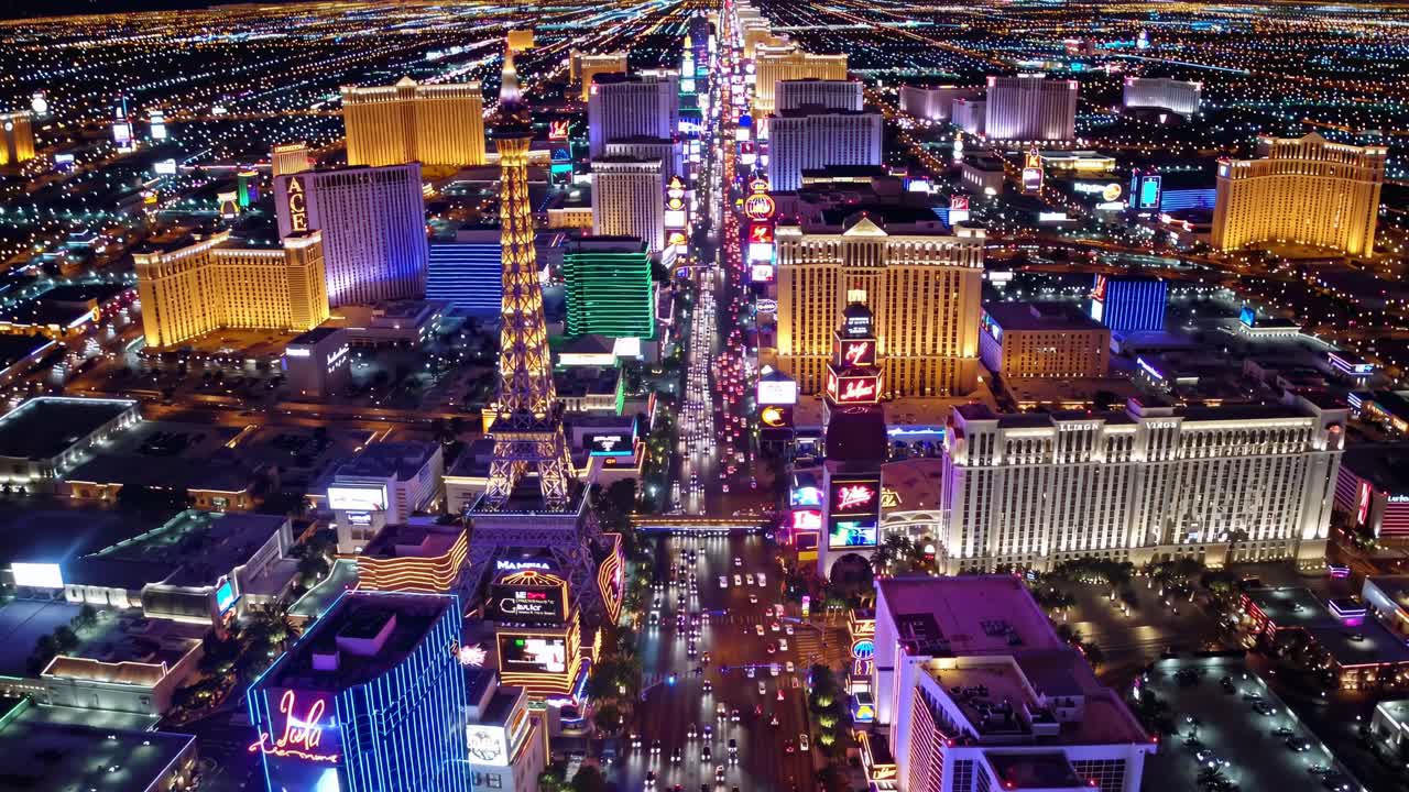 Aerial view of a vibrant cityscape at night, showcasing colorful neon lights and bustling streets