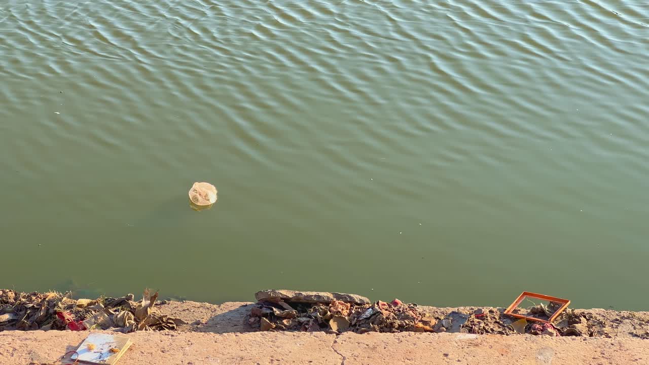 Plastic bag floating on the water of lake or pond in india, water pollution is a big problem in india