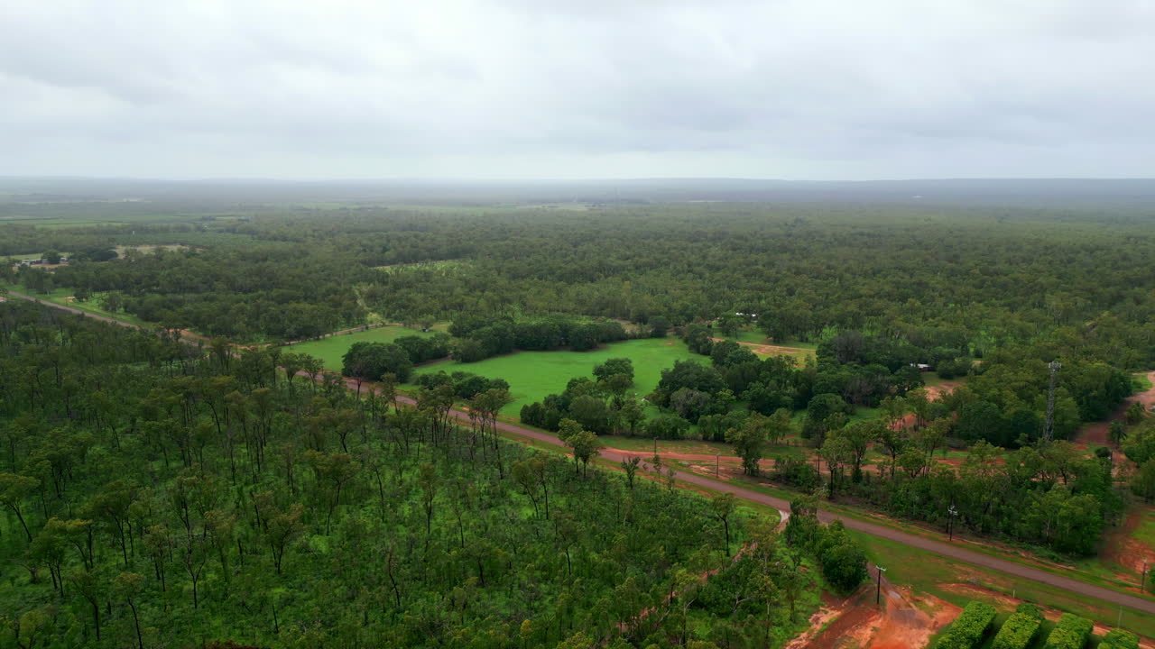 dron aéreo de la finca rural del interior con tranquilo camino de campo y horizonte nublado y brumoso, retroceso