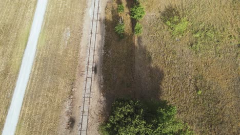 avanzando en el verano a través de un ferrocarril cerca de una fábrica