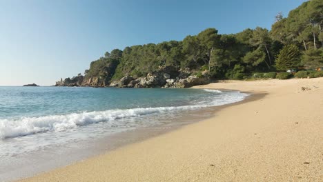 calm waves on a beautiful empty natural beach in costa brava coastline, spain