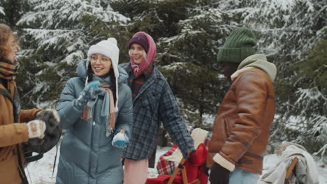 young friends dancing at campsite in winter forest