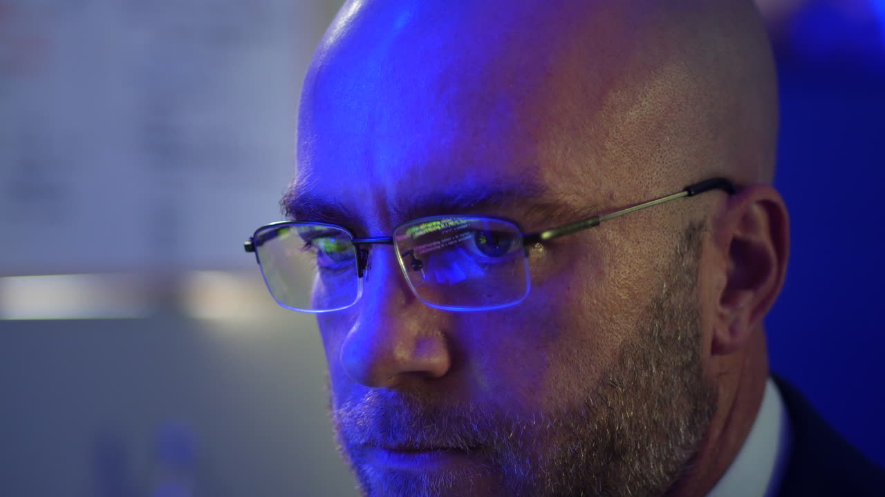 Close up of man using computer with refelction of code in his glases