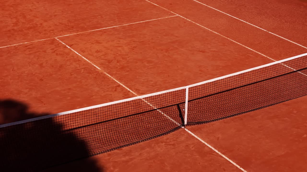 Close-up aerial drone slowly pulling back revealing the tennis net on a clay court in Italy, Italia, capturing a detailed summer sports scene
