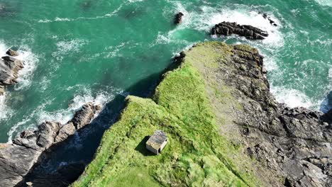 drone coast of ireland looking down static shot of old ww2 observation post on sea cliffs at the copper coast waterford on a summer day