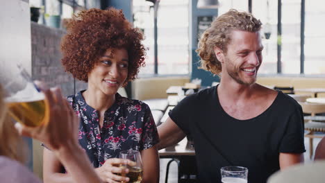 group of young friends meeting for drinks and socializing in bar