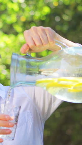 senior woman pouring lemonade from a jug