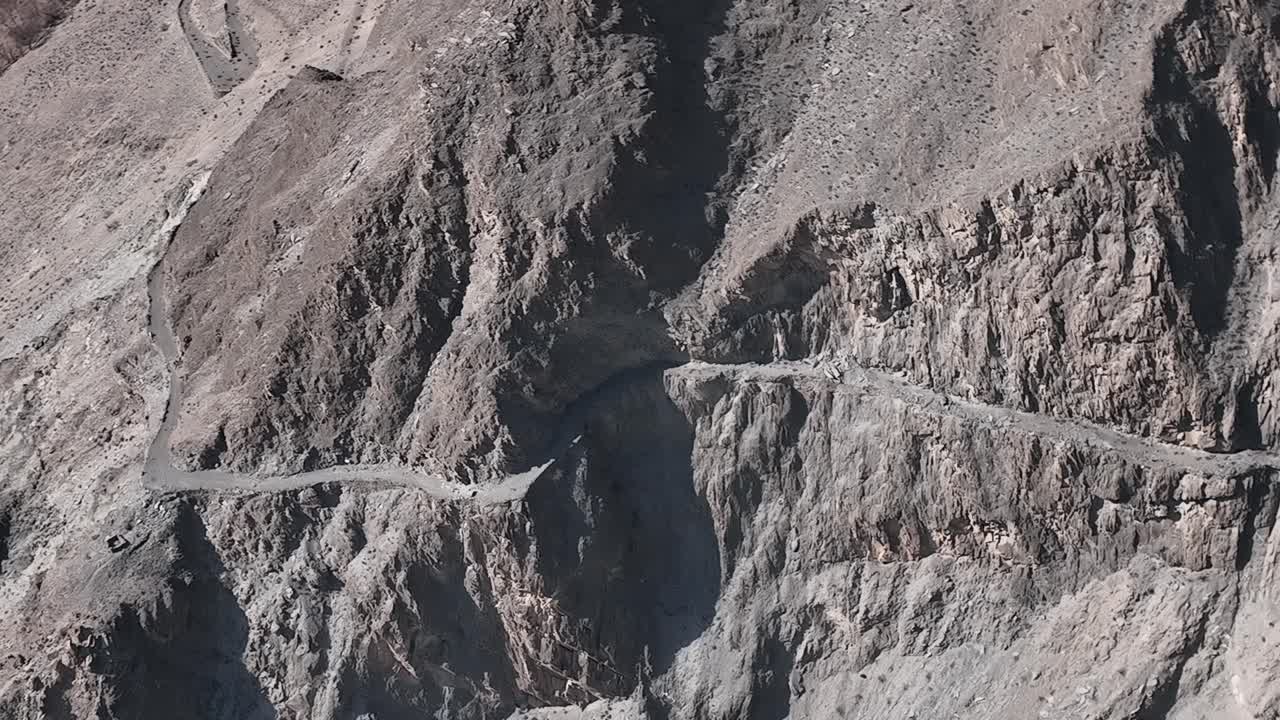 camiones paquistaníes viajan por peligrosas carreteras pavimentadas a lo largo de la montaña, transportan mercancías a través de la autopista karakoram