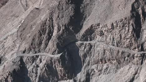 camiones paquistaníes viajan por peligrosas carreteras pavimentadas a lo largo de la montaña, transportan mercancías a través de la autopista karakoram