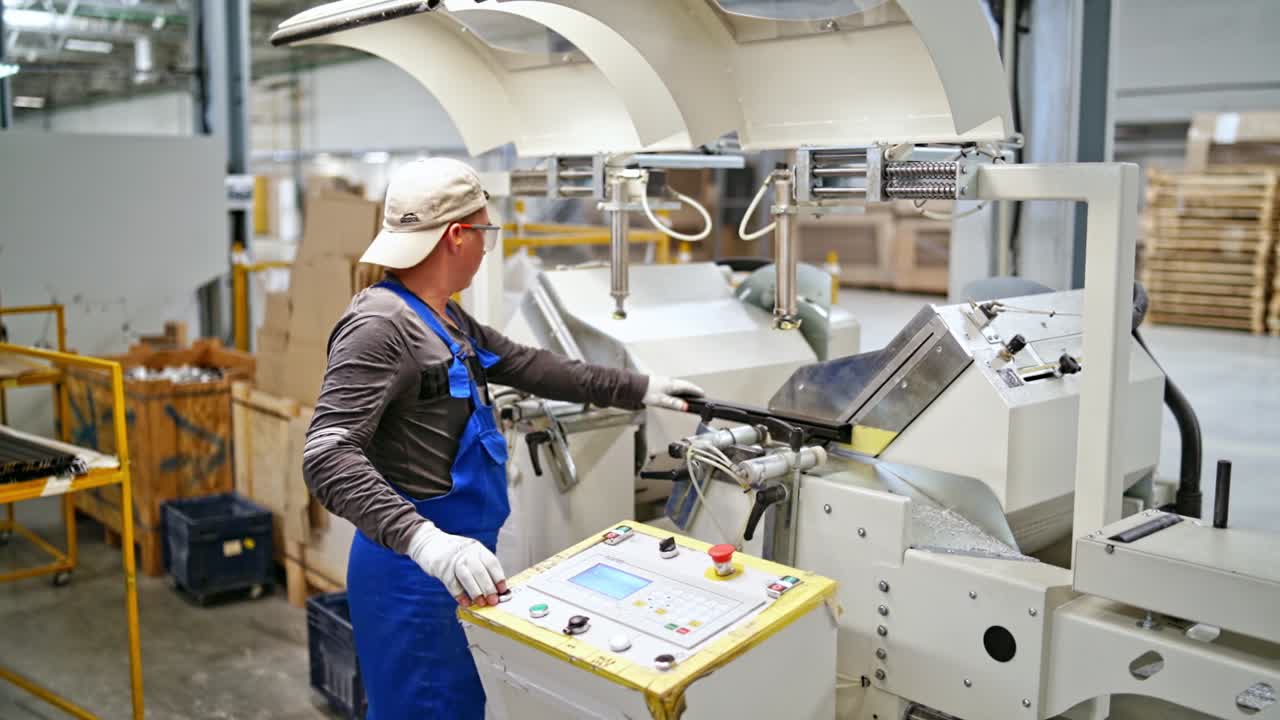 Man work at modern factory. Worker in protective clothing in factory using machine