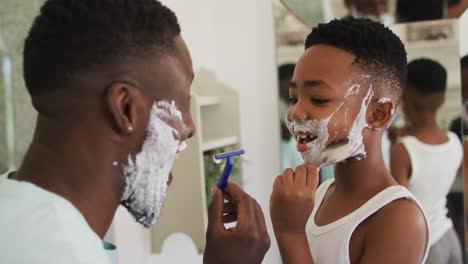 African-american-father-and-son-shaving-together