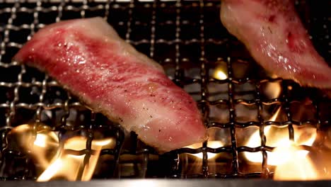 rebanadas de bistec cocinando en una parrilla en llamas