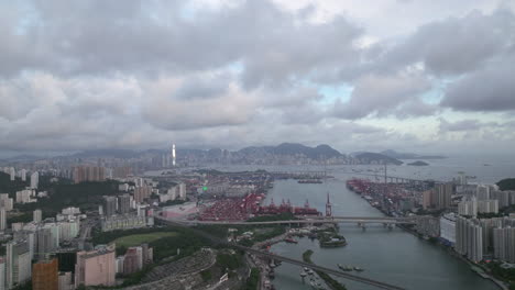 wide-angle shot of hong kong industrial por, urban skyline and low hanging scattered clouds, hong kong