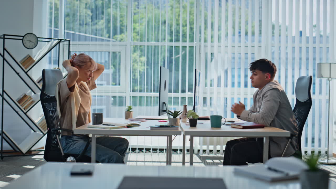 Tired partners working cabinet. Exhausted man stretching arms panoramic office
