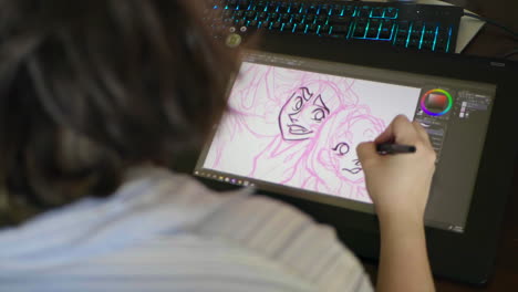 an over-the-shoulder shot of a caucasian woman drawing a digital illustration on a tablet in slow motion