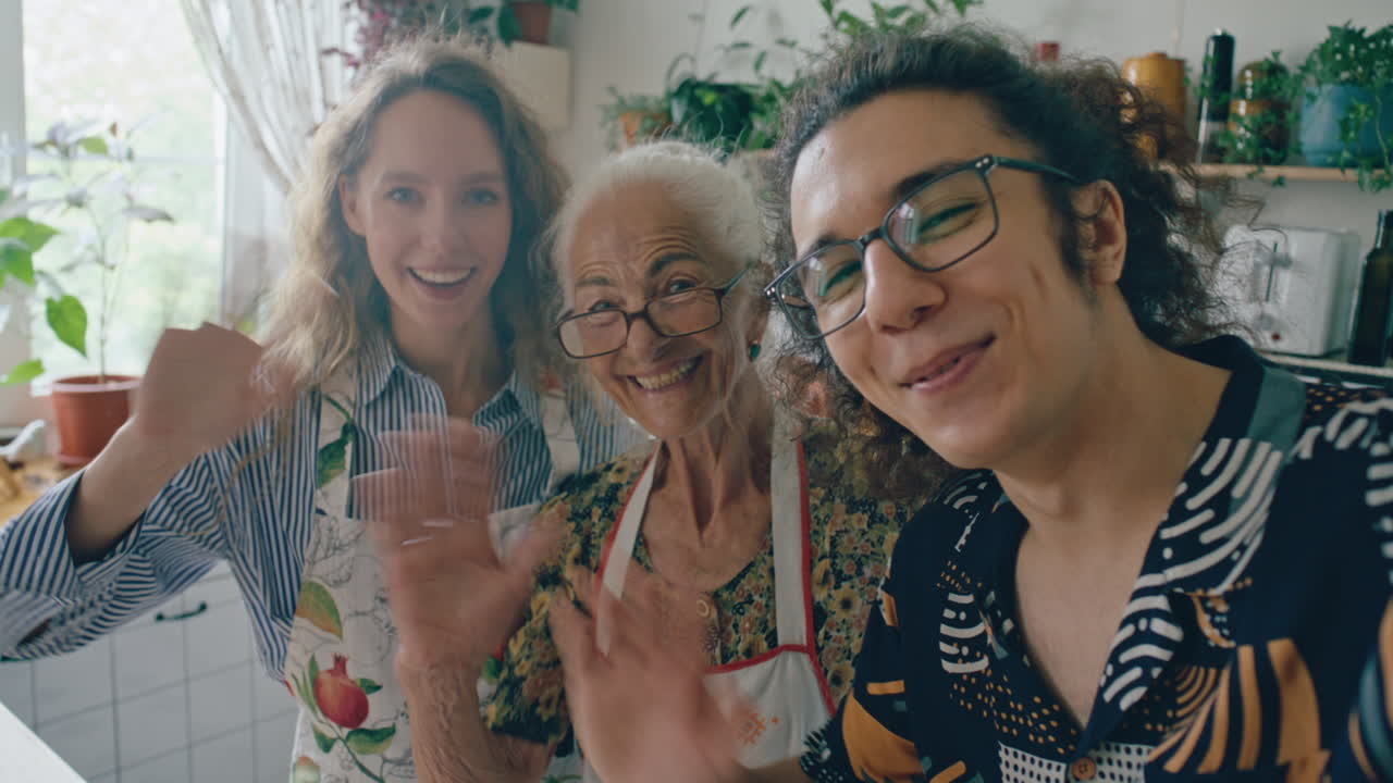 Happy Family Waving Together at Camera in Home Kitchen