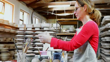 portrait of female potter checking mug 4k