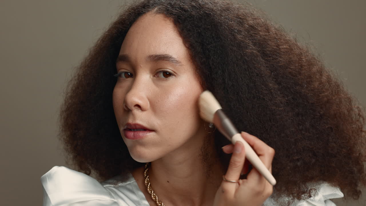 estudio, pincel y rostro de mujer con maquillaje