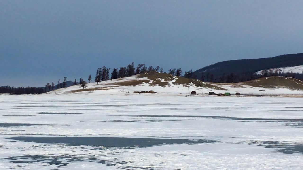 Snow-Covered Frozen Lake Khovsgol And Misty Mountains. Khatgal, Mongolia