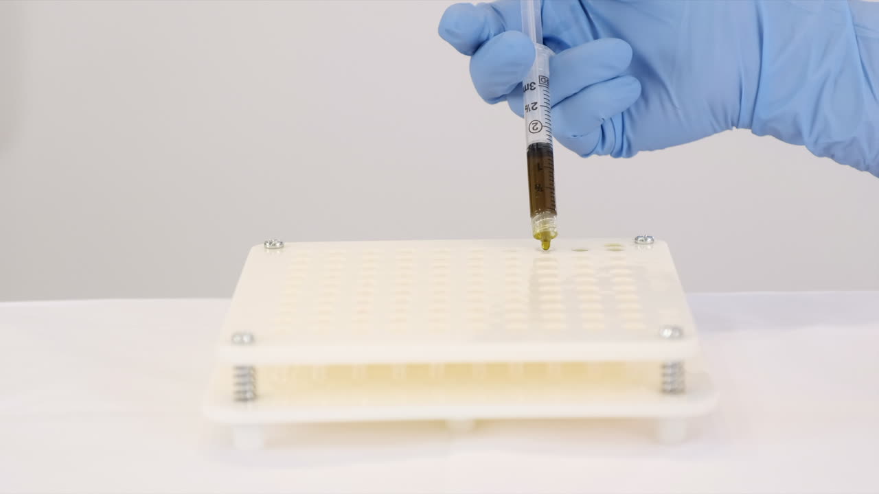 enfoque estrecho, jeringa con aceite infundido de cannabis goteado en cápsulas