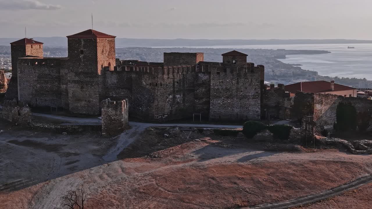 Un castello storico domina la costa della Grecia al tramonto.