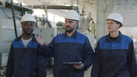 slowmo of supervisor showing new factory workers around