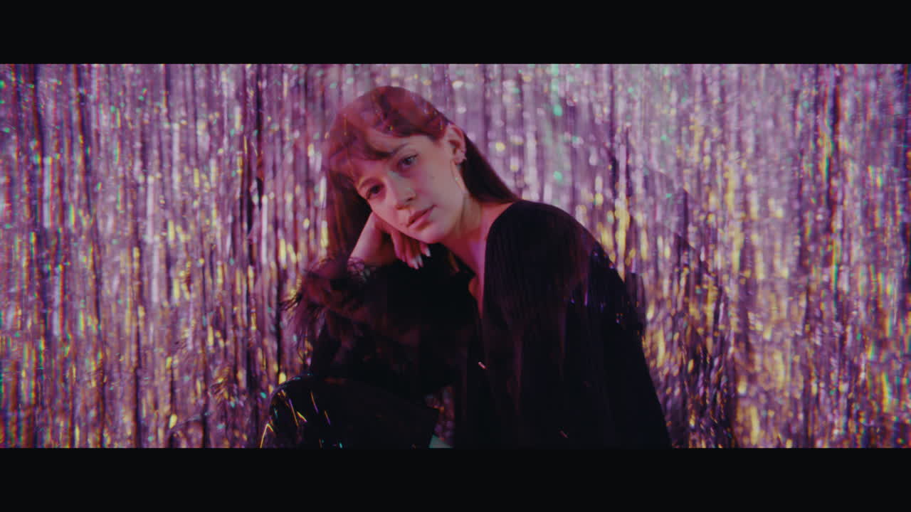 Woman in a black dress surrounded by glitter