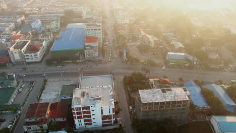 Drone-panning-shot-of-an-highway-intersection-in-Central-Mandalay-in-Myanmar-during-a-sunset