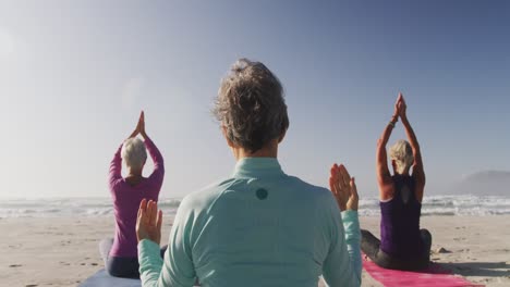 Mujeres-Atléticas-Realizando-Yoga-En-La-Playa