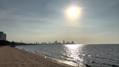 sunlit beach with city skyline in view